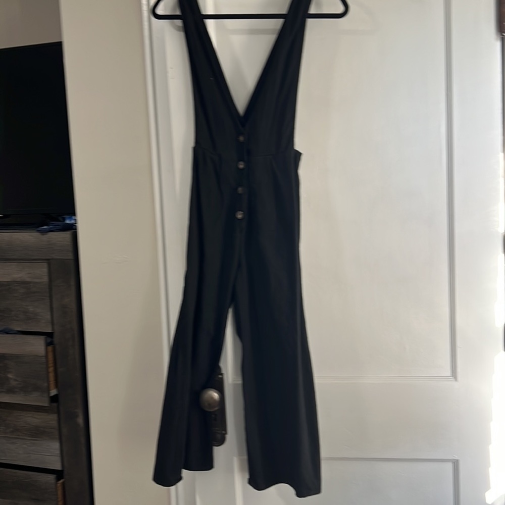 Sienna Sky Jumpsuit. Black with brown buttons, deep v-neck flare legs. Worn once